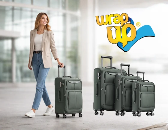 Adult traveler walking through an airport pulling a rolling suitcase, with a coordinated family luggage set visible beside them