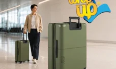 Traveler pulling lightweight checked travel luggage through a modern airport terminal