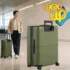 Traveler pulling lightweight checked travel luggage through a modern airport terminal