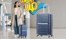 Adult traveler pulling smart hard shell luggage through a modern airport terminal with organized travel style